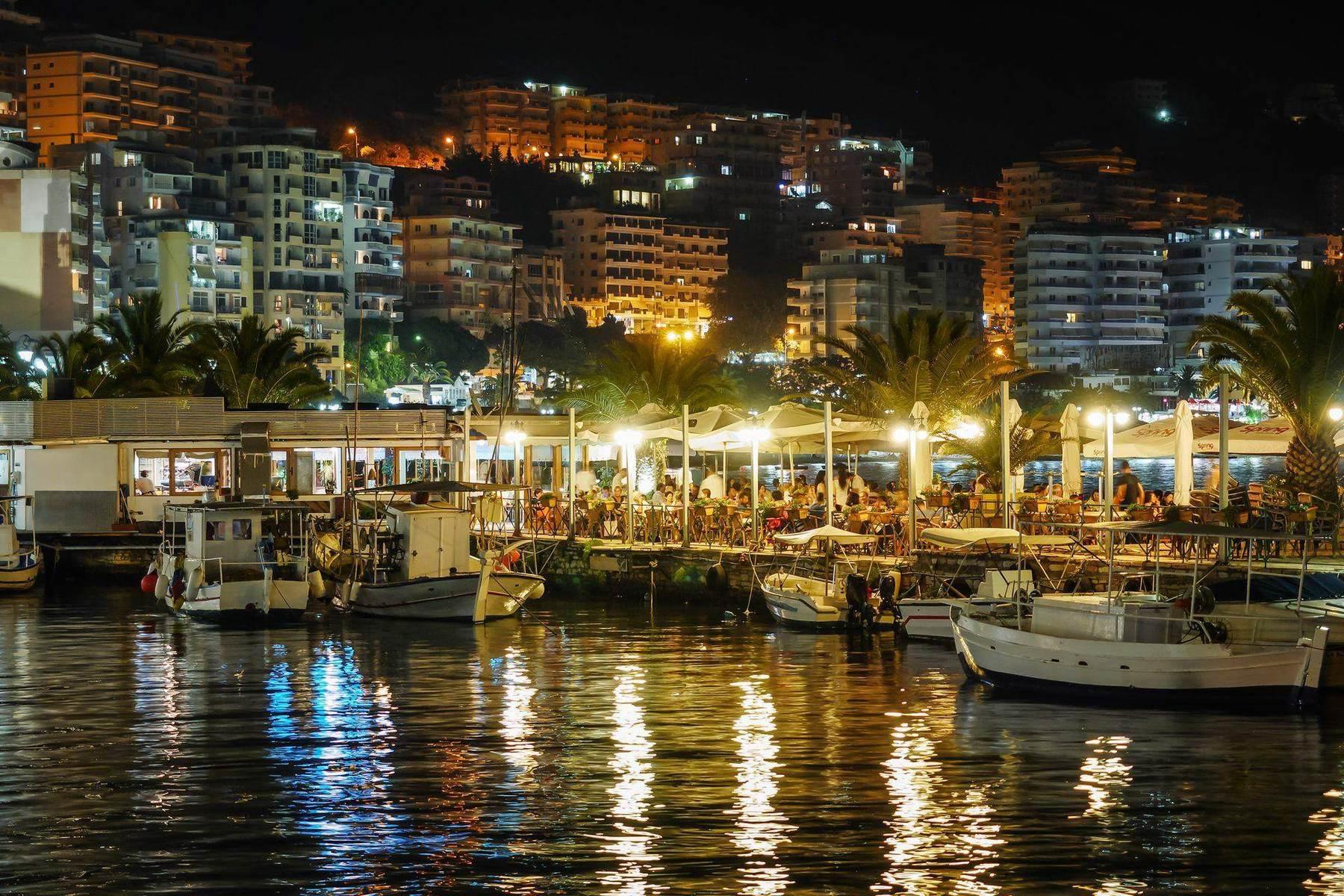 Il lungomare di Saranda di notte, con barche e luci, Riviera albanese